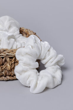 Lähikaader kohevast valgest sametist velvet juuksekummist punutud korvi taustal, ready-to-dye toorik.
